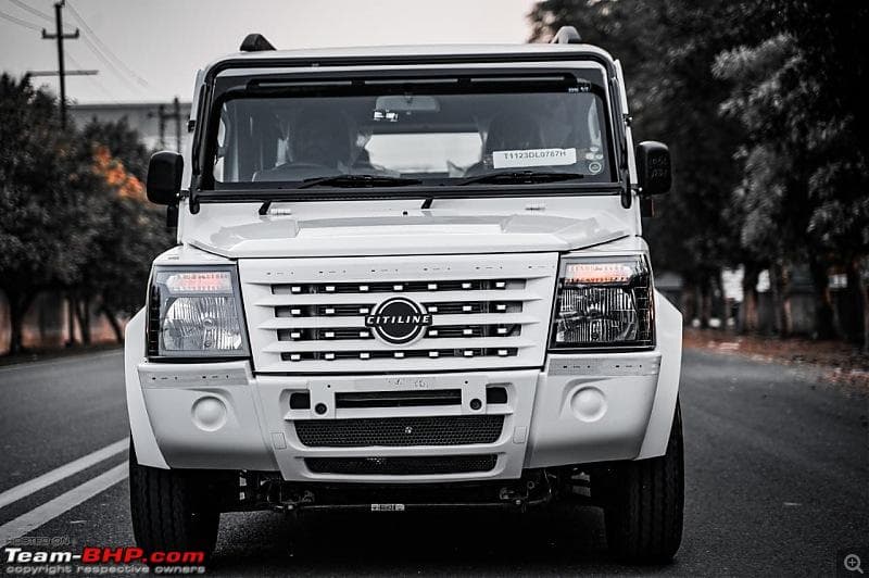 Front view of a white Force Citiline multi-utility vehicle parked on an asphalt road.